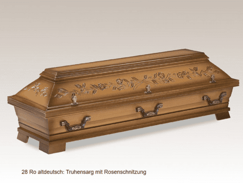 Brauner Tuhensarg mit Rosenschnitzung und verzierten Griffen auf einer hellen, neutralen Hintergrundfläche.