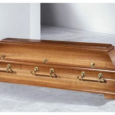 Holzner Sarg mit glänzenden Metallgriffen auf einem hellen Boden, vor neutralem Hintergrund.