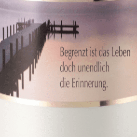 Beige Keramikkapselflasche mit einem gedruckten Spruch über Erinnerungen und einem Hintergrund von einem Steg am Wasser.