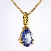 Goldene Halskette mit tropfenförmigem blauen Edelstein, der an einer gedrehten Fassung hängt.